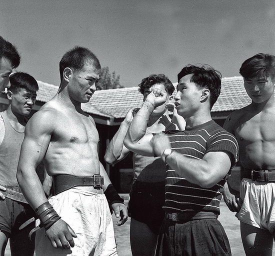 1959年，上，第一届全国运动会陈镜开（右二）为新疆运动员讲解技术动作